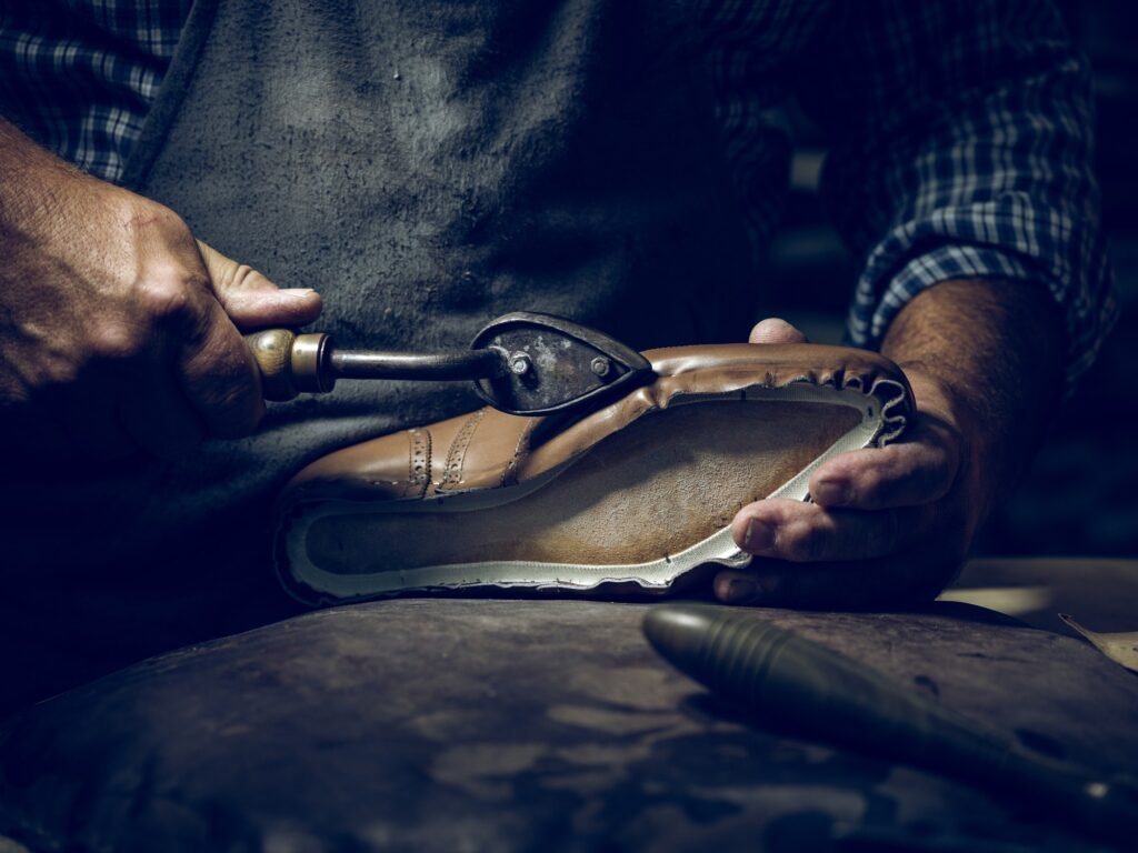 anonymous man making shoes